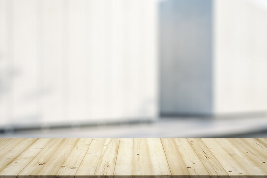 Empty wooden table with light sunny exterior wall on background, mock up