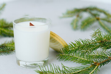 Soy candles in transparent glass jar with wooden lid. Candle on light background close-up.