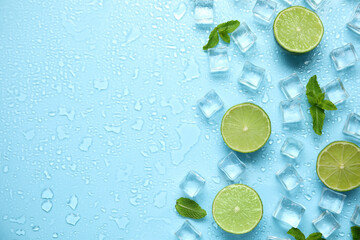 Ice cubes, mint and cut limes on turquoise background, flat lay with space for text. Refreshing drink ingredients
