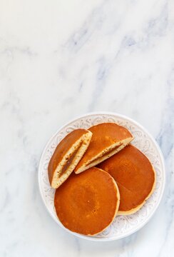 Homemade pancakes with caramel close-up. Delicious breakfast. Stuffed pancakes. Marble background. Selective focus, top view and copy space