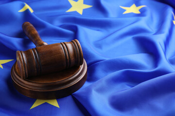 Wooden judge's gavel on flag of European Union, space for text