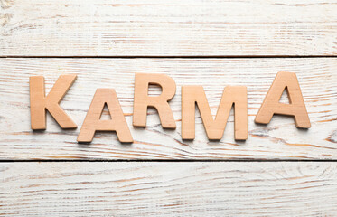 Word Karma made with letters on white wooden background, top view