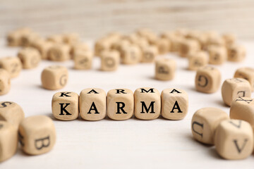 Word Karma made of cubes with letters on white table