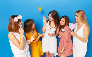 Front picture of a group of joyful women to have gender reveals envent, isolated light blue...