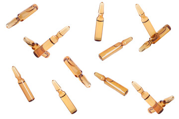 Many glass ampoules with pharmaceutical products falling on white background