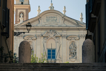 Impressive view to Roman Catholic church with blue sky in background and stone building walls and massive stone stairs in the foreground.