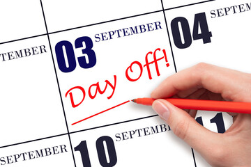 Hand writing text DAY OFF and drawing a line on calendar date 3 September . Vacation planning concept.