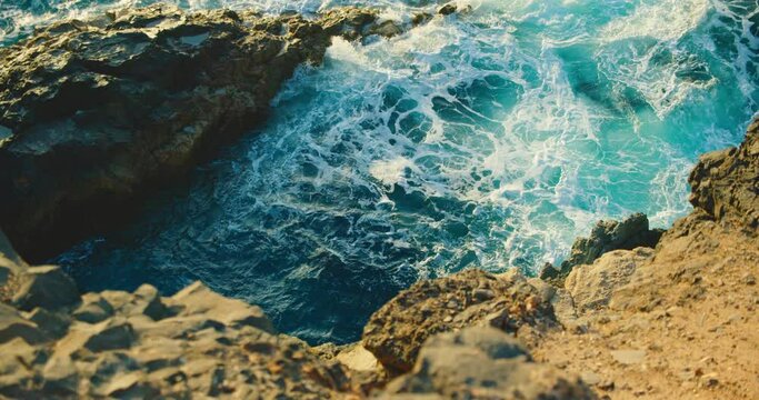 The ability of the ocean to self-heal and self-purification of the waters of the world. Unpolluted environment. The untouched beauty of nature. Splashing water on rocks at sunset in slow motion.