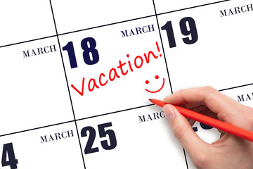 A hand writing a VACATION text and drawing a smiling face on a calendar date 18 March. Vacation...