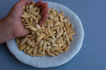 Close Up Of Toasted, Salted Pumpkin Seeds in child hand