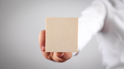 Male hand holding wooden empty board for your text.