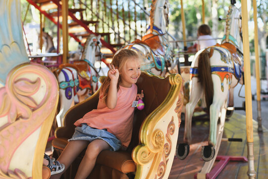 Girl on the carousel. Horses on a carnival Merry Go Round