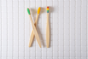 Roman numeral XI composed of toothbrushes on a white tiled background
