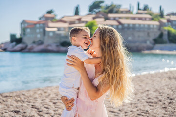 Mother and son tourists on background of beautiful view St. Stephen island, Sveti Stefan on the Budva Riviera, Budva, Montenegro. Travel to Montenegro concept