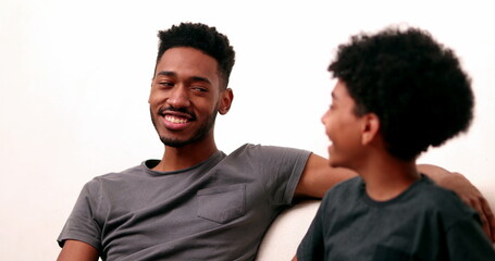 Older brother chatting with younger sibling. Candid mixed race two brothers in conversation