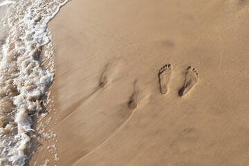 Two sets of footprints in the sand on a walk in Maui Hawaii