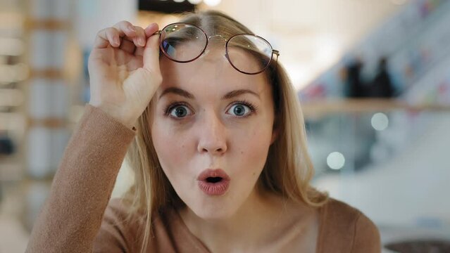 Close up female amazing face portrait emotional confused girl surprised opening mouth takes off glasses woman amazed incredibly impressed wow reaction unexpected news lady smiling glad victory offer