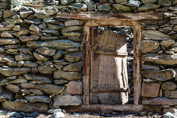 Wooden door and stone wall in Karakorum mountains on the way to Rakaposhi base camp. Minapin village, Karakoram, Pakistan