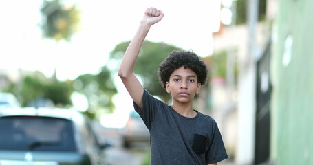 Mixed race kid raising fist in the air political protest
