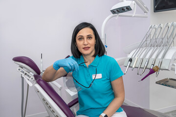 young female dentist in a private clinic with modern dental equipment standing and smiling.