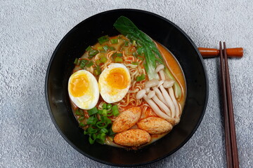 Delicious ramen with boiled egg,mushroom and vegetable  in black bowl 