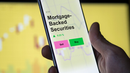 MBS, Mortgage-backed securities etf fund on a screen. A phone shows the prices of mortgage backed securities ETF