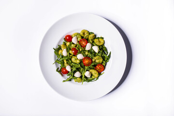 Pasta with mozzarella, lettuce, arugula, tomatoes and pesto