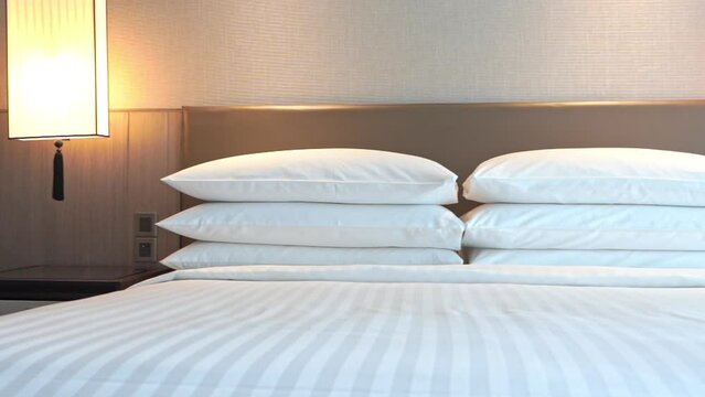 Clean made-up king's size hotel bed with many pillows 