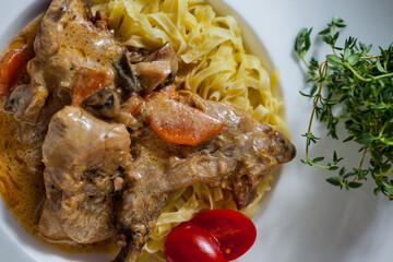 Pasta with meat on the bone and tomatoes