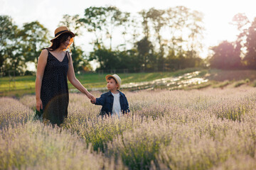 Happy mother and little son spend time together in lavender field