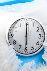 A clock striking 6 a.m. An analogue clock on a pillow with white wings. Awakening. Time-management concept