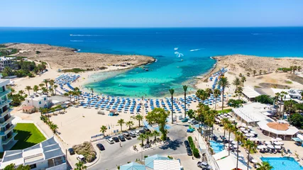 Schilderijen op glas Aerial bird's eye view of Vathia Gonia beach, Ayia Napa, Famagusta, Cyprus. Landmark tourist attraction rocky bay with golden sand, sunbeds, sea restaurants in Agia Napa on summer holidays from above © f8grapher