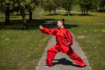 Asian woman in red kimano practicing taijiquan outdoors, chinese martial arts, healthy lifestyle...