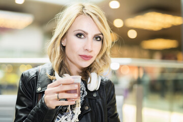 Woman holding a glass of tea in a public place