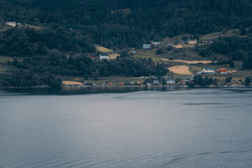Fototapeta na wymiar Fotografías de los fiordos Noruegos hechas desde el fiordo a la costa donde se ven las casas típicas y paisajes noruegos