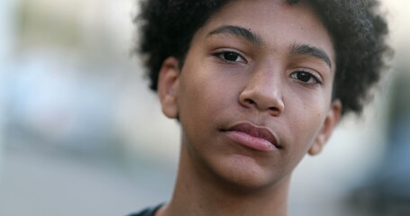 Serious mixed race young boy looking at camera. Black ethnic kid portrait