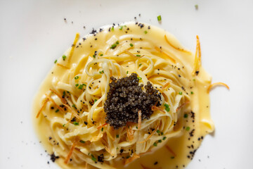 Spaghetti with sauce, sweet potatoes and black caviar