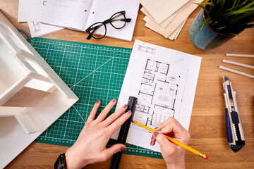 POV Shot Of Female Architect Working In Office Measuring Plans For New Building