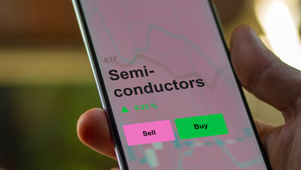 Un investisseur analyse le fonds ETF de semi-conducteurs sur un écran. Un téléphone affiche les prix des semi-conducteurs, texte en anglais.