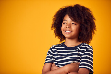 Studio Portrait Of Smiling Young Boy Shot Against Yellow Background