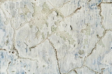 Old and dirty crumbling wall with peeling paint and cracks texture. Grunge interior background closeup