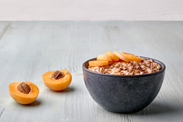 Whole grain oatmeal with flax seeds and apricot pieces on a painted blue wooden table