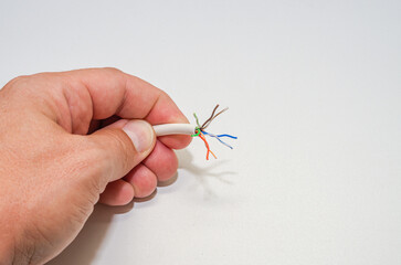 A computer wizard strips the wires of an Internet cable for connecting a twisted pair cable to a...