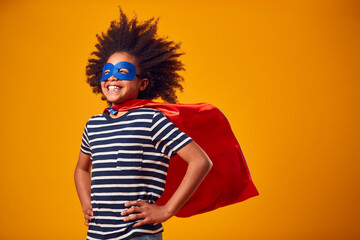 Studio Portrait Of Boy Dressed As Comic Book Superhero Against Yellow Background - Powered by Adobe