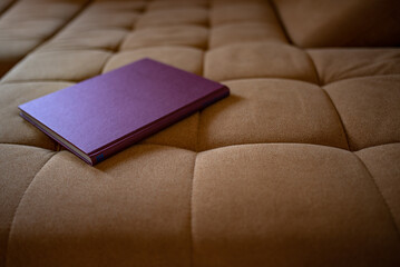 a red book on a light brown couch