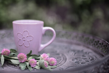 lilac coffee cup and colorful lilac flowers on garden table