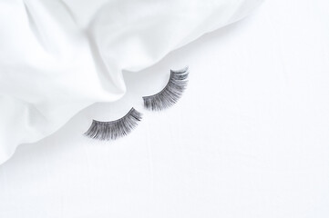 close up of strip fake lashes on the bed, without make up concept