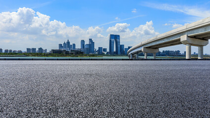 Asphalt road and city skyline with modern building in Suzhou, China.