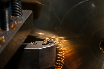 Close-up the lathe machine finish cutting the brass disk parts by lathe tools.