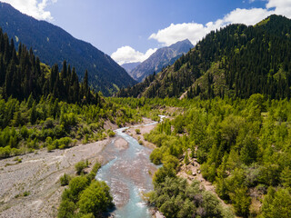 Obraz premium The Issyk River is above the lake. The valley of the mountain river is high in the mountains. Beautiful mountain landscape. Aerial photography of a mountain river.